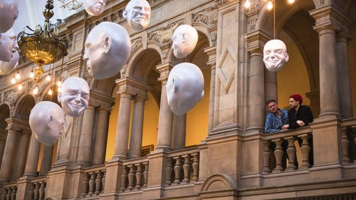 Two men looking at installation of suspended head sculptures - photo by VisitBritain/Tommy Ga-Ken Wan/Sophie Cave