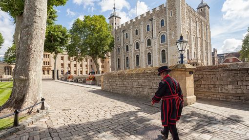 Beefeater walking by the, Tower of London on a sunny day