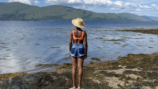 A woman stands on a rock looking over Loch Linnhe, in the Highlands, Scotland