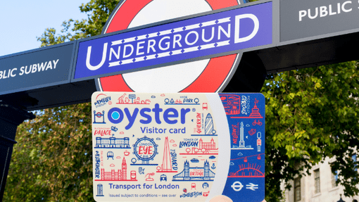 A customer holding the Visitor Oyster card near an Underground sign