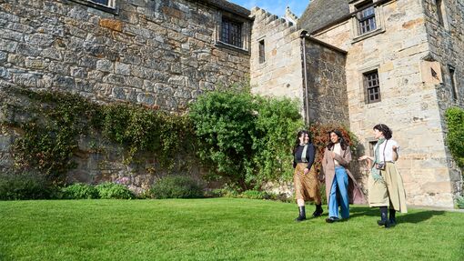 Three women exploring the grounds of a castle
