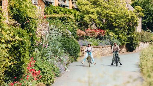 A couple cycling through the Cotswolds