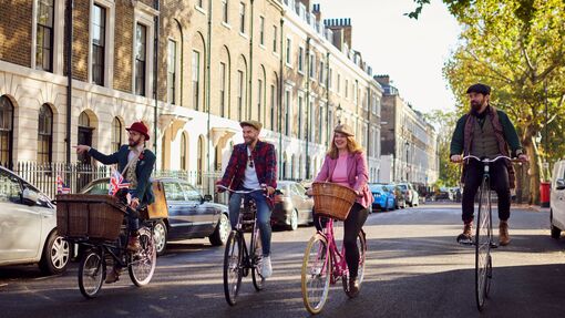 Four people on a guided tour on bicycles on a city road