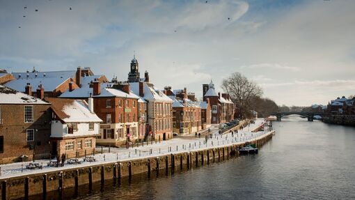 A view across a river to a town covered in snow