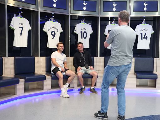 Two young men get photographed in front of players shirts at Tottenham stadium