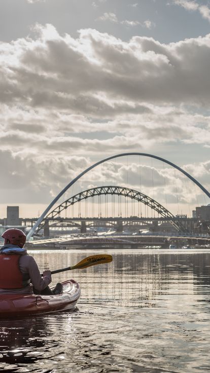 Couple kayaking on a river under blue skies