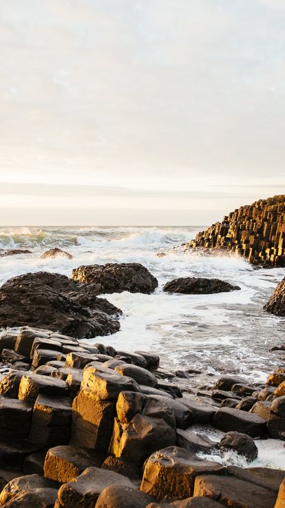 Rock formations coming out of sea. Crashing waves. Dusk