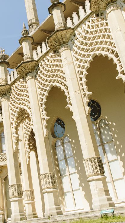 A man, mid-jump, in front of pavilion lattice screens