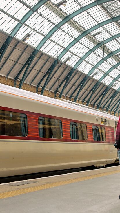 A couple standing on a platform, waiting for a train