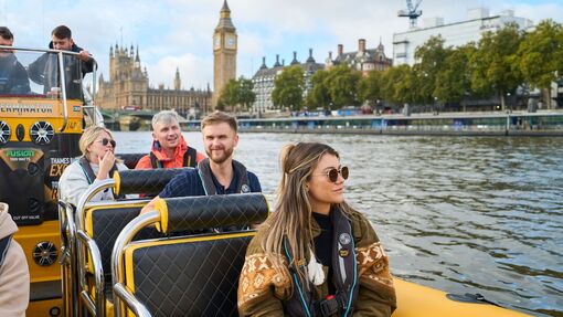 Tourists enjoying a speedboat ride on the Thames with Big Ben in the background