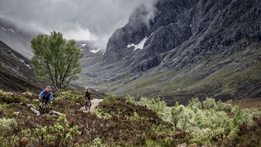 Two mountain bikers cycling on a trail in Fort William