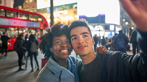 A couple taking a selfie at Piccadilly Circus in London