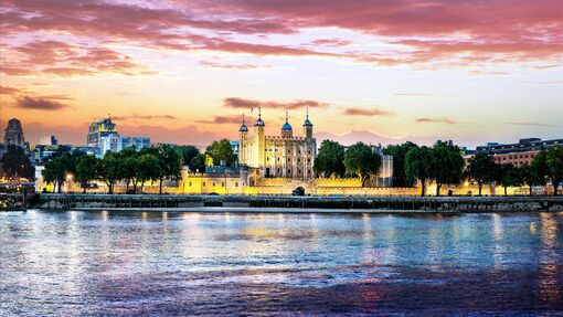 Tower of London lit at dusk from across the Thames