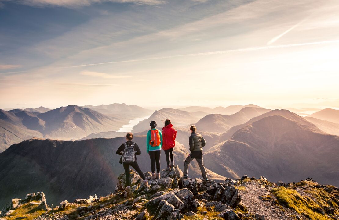 People standing on high point looking down at mountain view