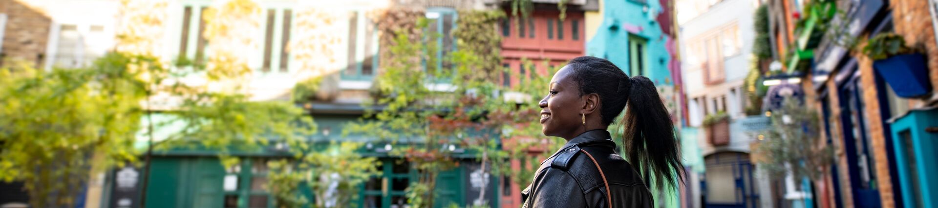 Female tourist exploring a London shopping courtyard with shops and outdoor seating