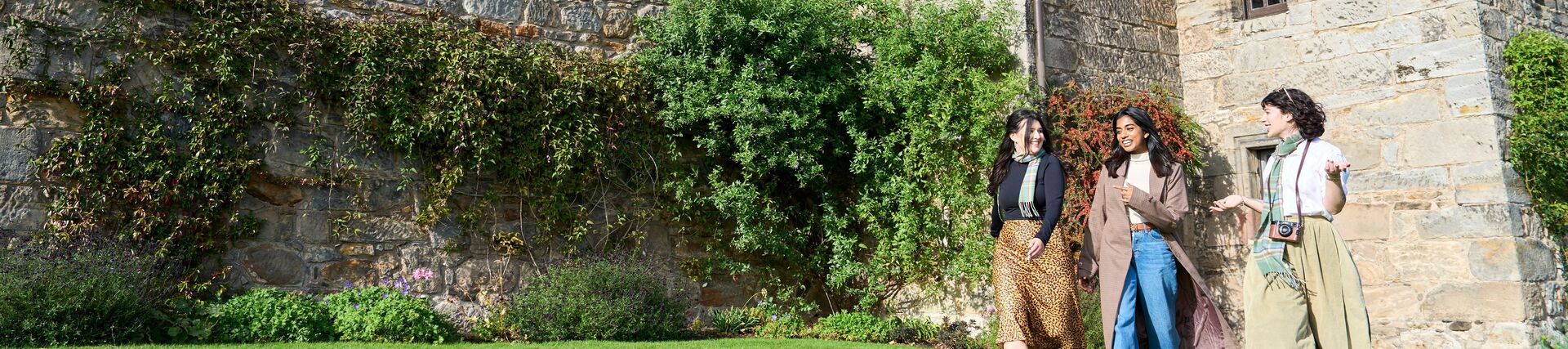 Three women exploring the grounds of a castle