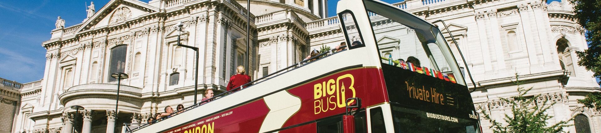 People enjoying an open top bus excursion exploring the city sights