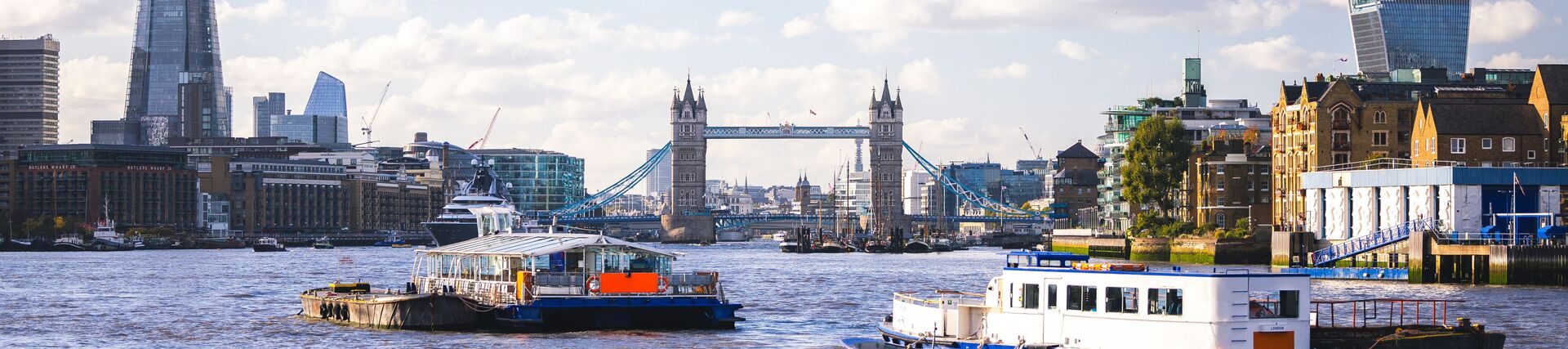 A city scene showing river boats and buildings