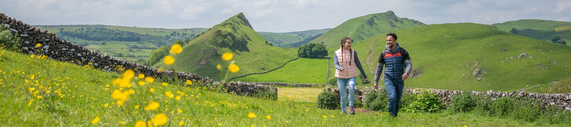 A man and a woman walk in open countryside