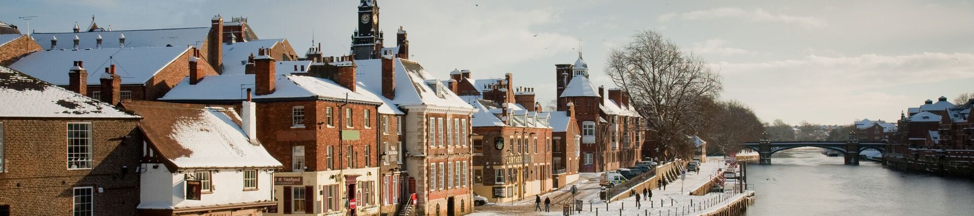 A view across a river to a town covered in snow