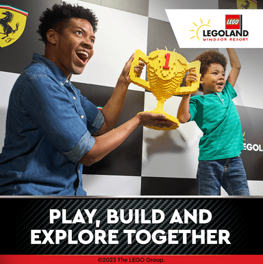 A father and son raise a Lego trophy after they built their own race car at Legoland Windsor
