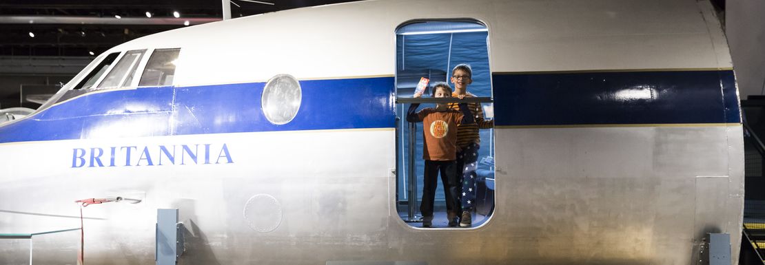 The Britannia airplane is being explored by children as they stare out the open side door