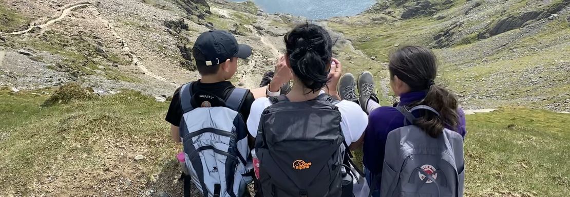 Young people reflect on the sight together as they climb Mount Snowdon together