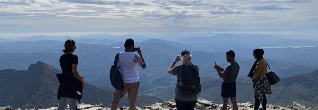 A group of hikers look off into the distance as they climb up Mount Snowdon.