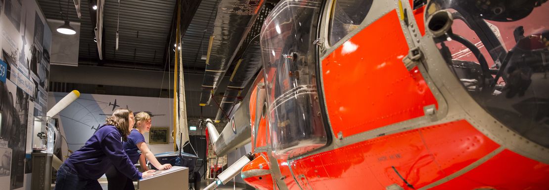 Children view a bright orange helicopter as a smile comes over their faces.