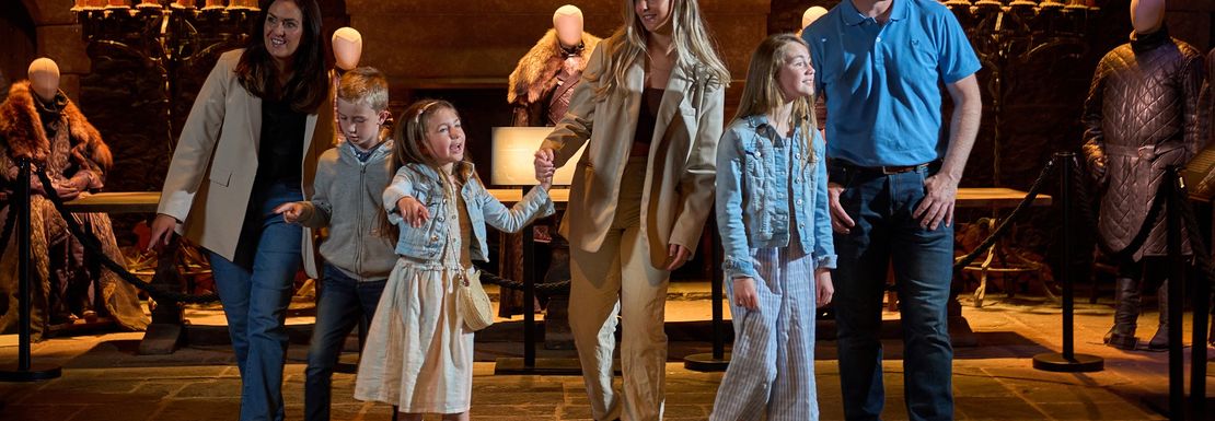 A family gathers in the Game of Thrones Family Winterfell Great Hall on the tour