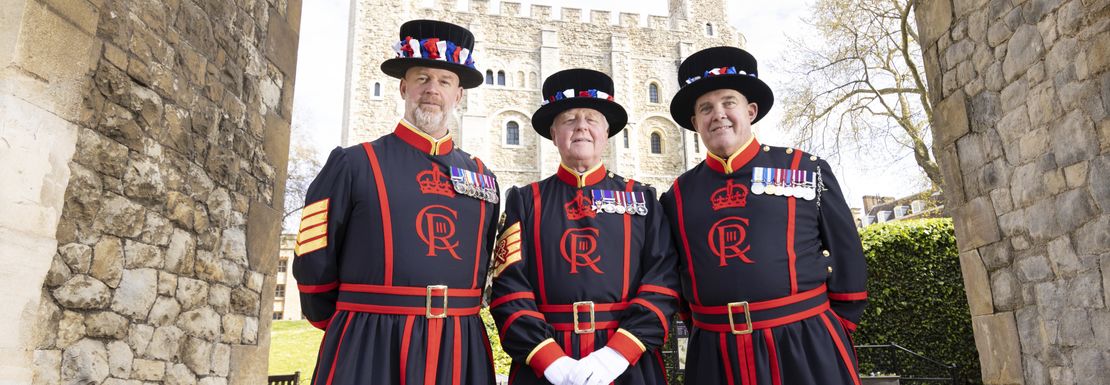 3 Yeoman Warders in Ravens Arch at the Tower of London pose for the camera in full uniform