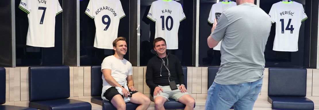 Two young men get photographed in front of players shirts at Tottenham stadium