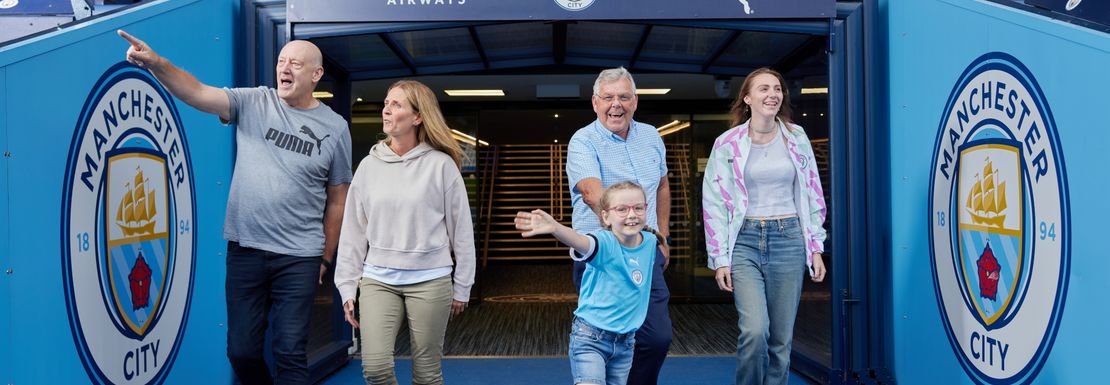 Fans on the Manchester City Stadium tour walk out to the stadium