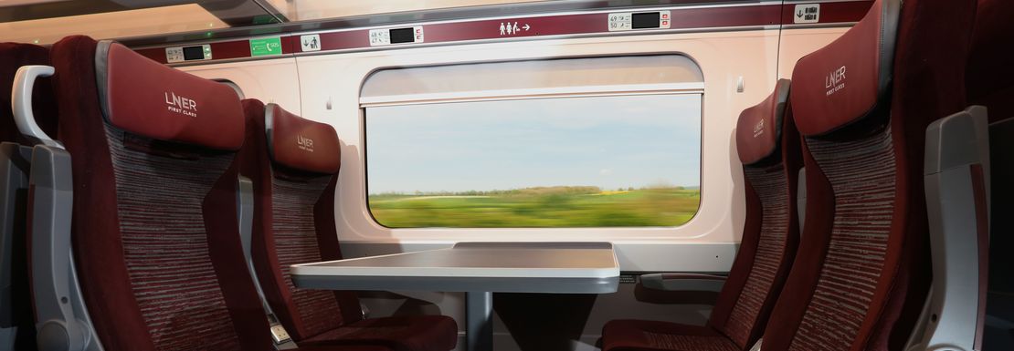 Comfortable seats and shared tables inside a LNER London Northern Eastern Railway train