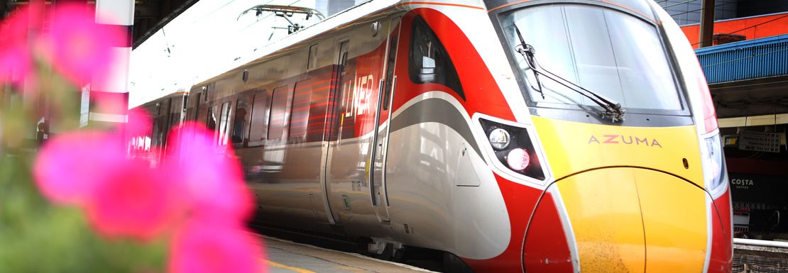 A LNER London North Eastern Railway train standing by the platform with flowers