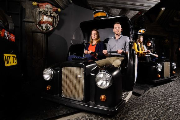 a couple enjoy the Spirit of London ride at Madame Tussauds while sitting in black taxis
