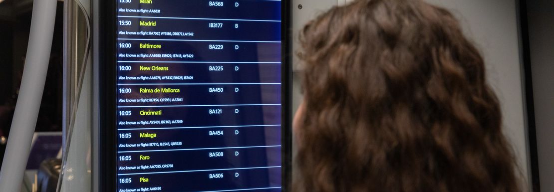 A woman looks at one of the many electronic timetable signs for the Heathrow Express