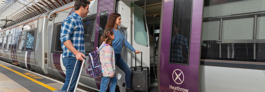A family easily boards the Heathrow Express train together with their luggage