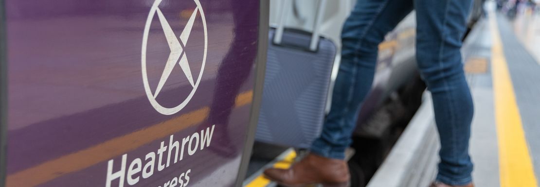 A man easily boards the Heathrow Express with his luggage at Paddington Station