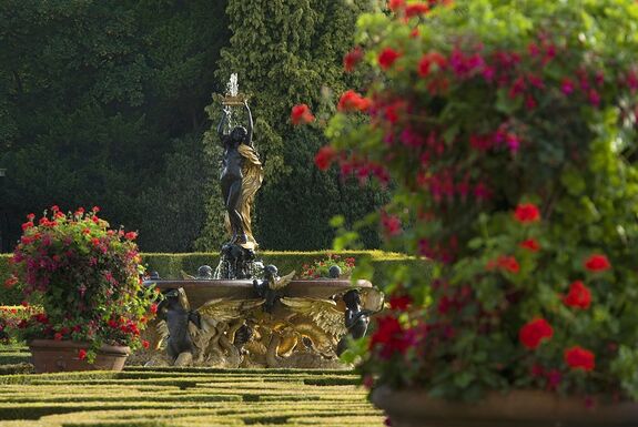 Blenheim Gardens with a statue surrounded by red flowers in giant potted plants