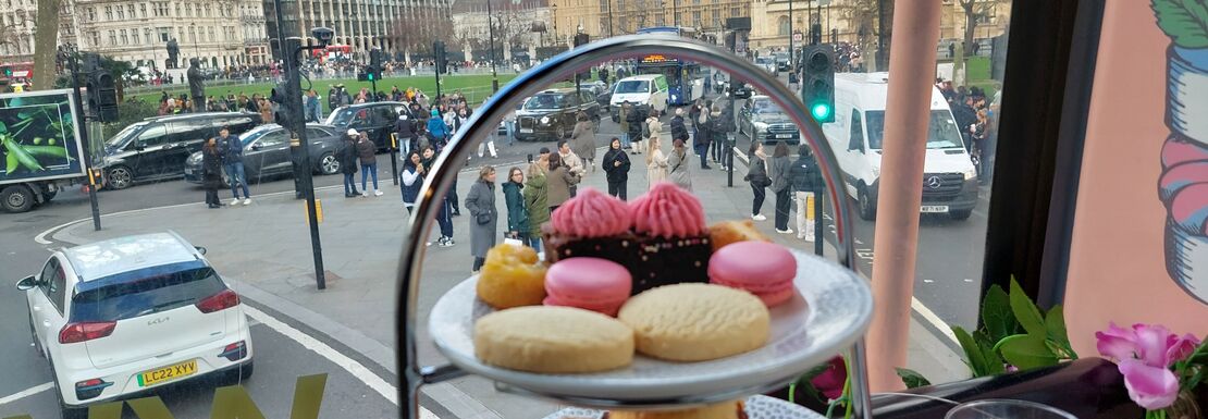 A serene afternoon tea setting with Big Ben in the background, showcasing a delightful assortment of pastries and tea.