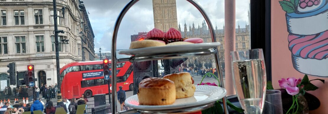 A delightful afternoon tea in a double decker bus with Big Ben in the background, showcasing London’s charm and elegance.