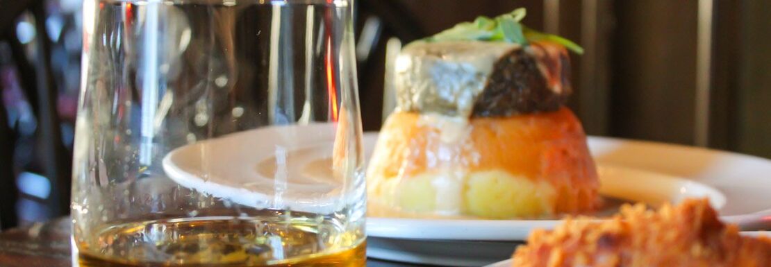 A close up shot of a dram of whisky and haggis taster at the Tolbooth Tavern in Edinburgh