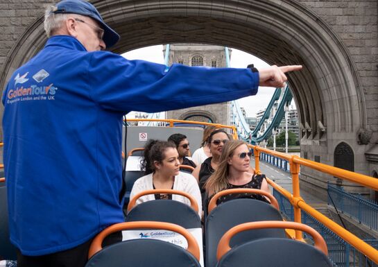 A tour guide in a blue jacket points out sights to visitors in London