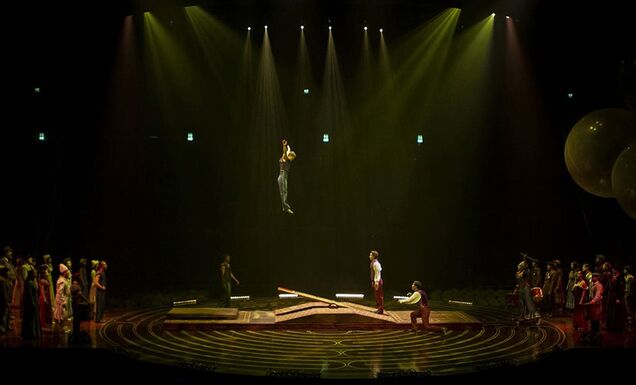 Cirque du Soileil performers doing an acrobatic routine on a teeterboard