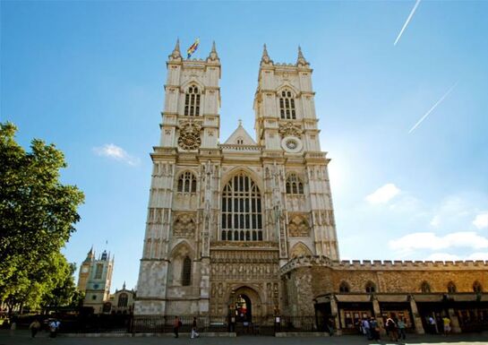 An exterior shot of the facade of Westminster Abbey on a blue-sky sunny day