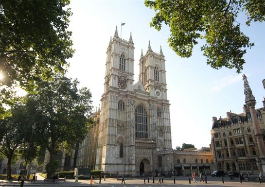 An external shot of Westminster Abbey on a sunny day with trees in the foreground