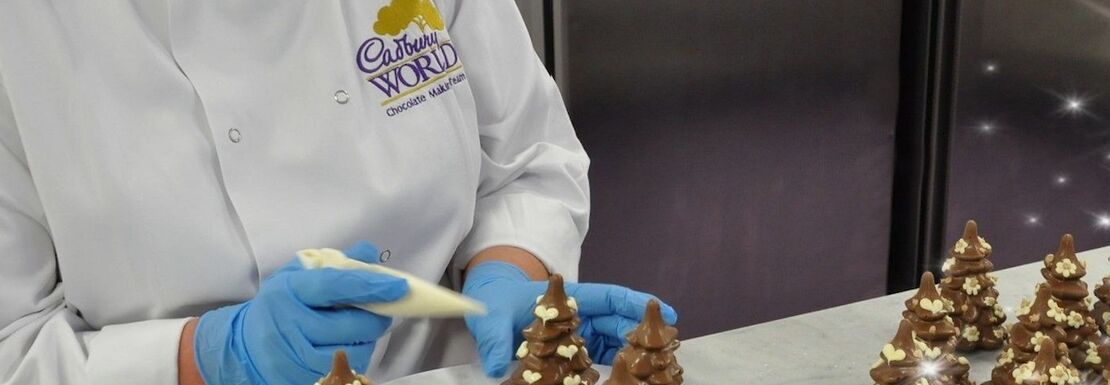 A chocolate maker at Cadbury World making chocolate Christmas trees