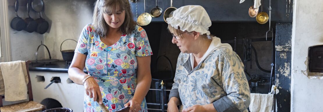 Costumed interpreter making old fashioned desserts in the kitchen at Wordsworth House in Cumbria