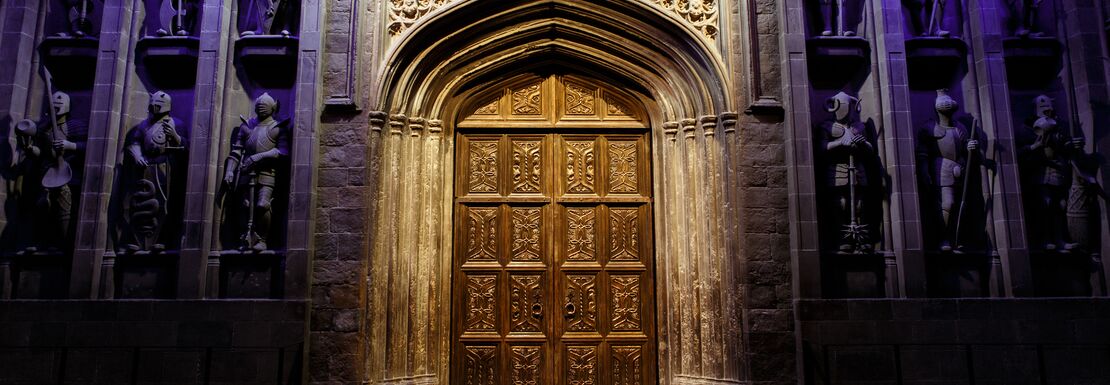 The Great Hall thick wooden doors inbetween regal looking purple curtains